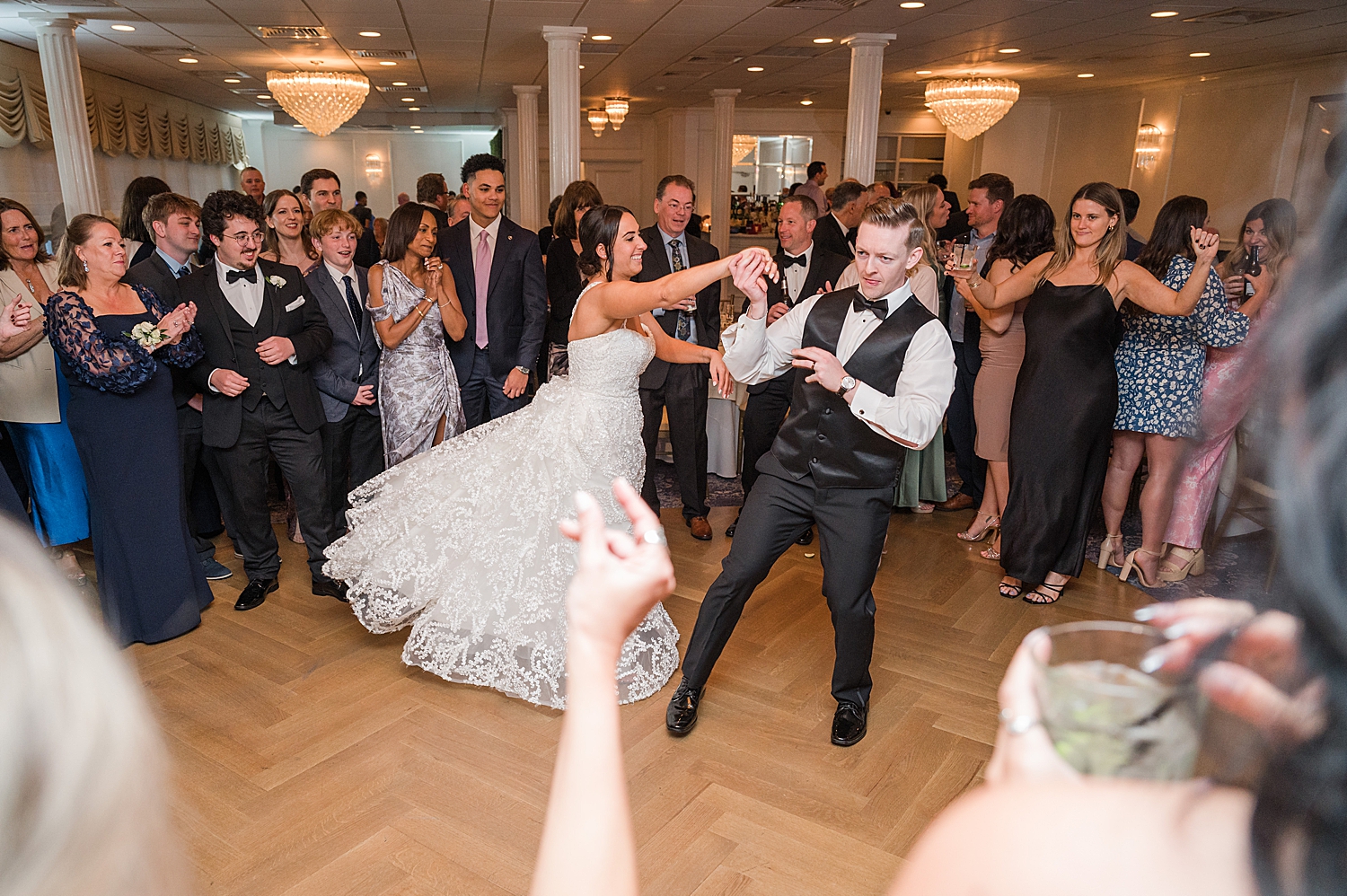 bride and groom do fun dance while guests surround them