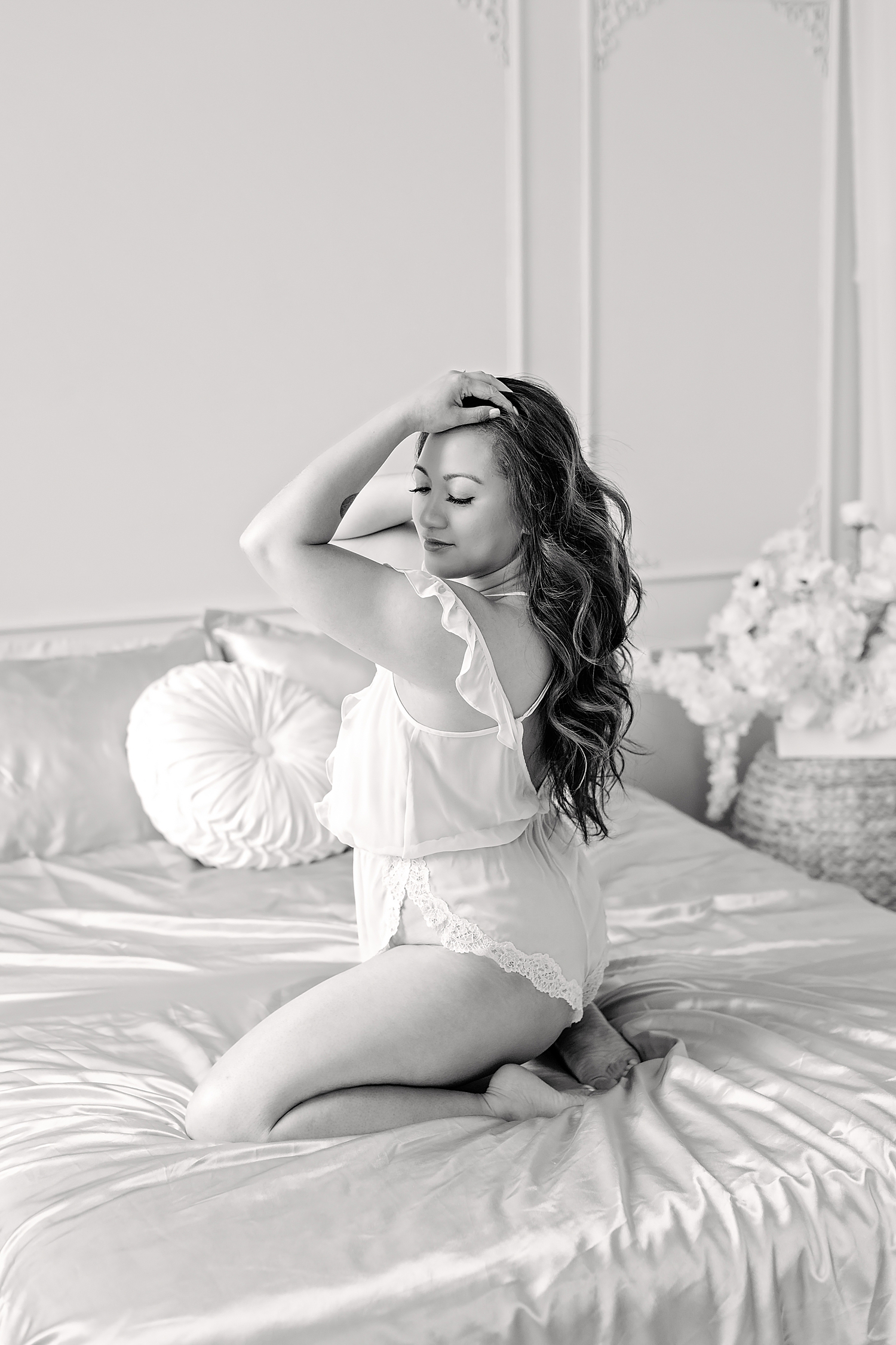 black and white photo of woman on bed from boudoir session